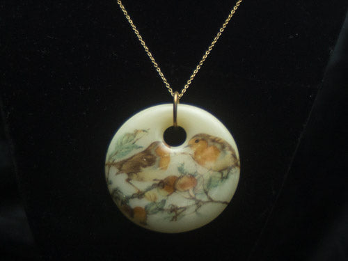 BIRDS WITH FLORAL AND TREE SETTING ON OFF WHITE FUSED GLASS CABUCHON.   CERAMIC DECAL IS FUSED UNDER HIGH TEMPERATURE IN THE KILN AND BECOMES PERMANENTLY PART OF THE GLASS.   IT COMES ON A 20 INCH GOLD PLATED NECKLACE AND IS GIFT BOXED FOR YOUR CONVIENIENCE SIMPLY WRAP AND PRESENT TO YOUR LOVED ONE.   PENDANT MEASURES 2 INCHES IN DIAMETER